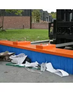 Forklift-mounted yard brush attachment sweeping debris with durable bristles