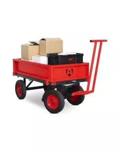Heavy-duty red platform turntable truck trolley loaded with boxes, featuring large pneumatic wheels and T-bar handle for easy manual manoeuvring on industrial sites